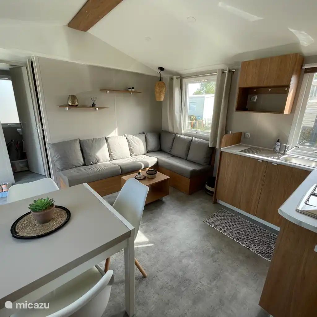 Gemuetliches Wohnzimmer in der Ferienwohnung "Azalee", einem Chalet in Bruegge, Westflandern, mit bequemen Sofas und einer modernen Kueche.