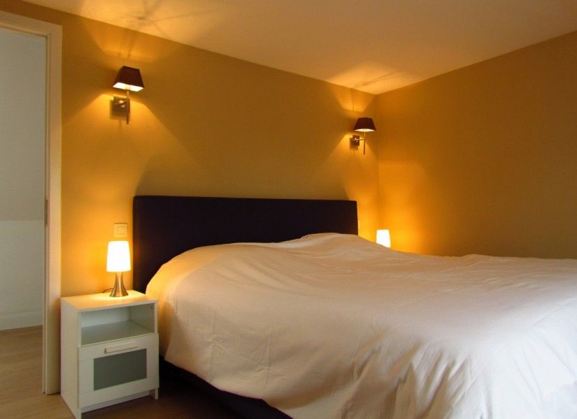 Gemuetliches Schlafzimmer im Ferienhaus Hof ter Harte, Ypern, Westflandern, mit weicher Bettwaesche und warmen Lampen.