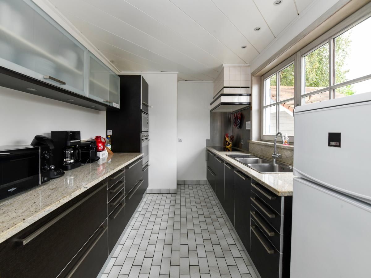 Gezellige eetruimte in vakantiehuis Floribert, Nieuwpoort-Bad, met uitzicht op groene tuin, ideaal voor familiebijeenkomsten in West-Vlaanderen.