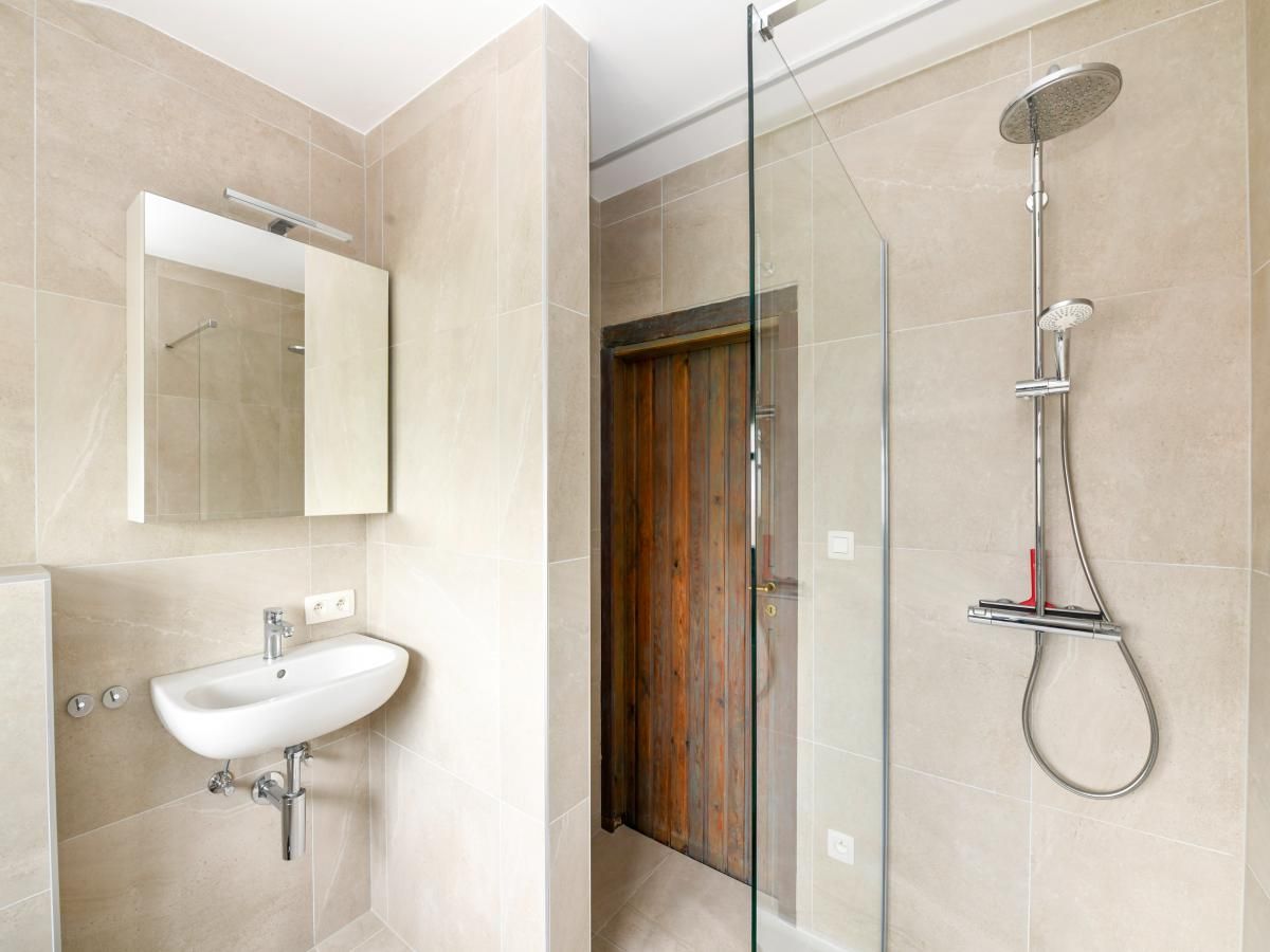 Moderne badkamer in vakantiehuis Floribert, Nieuwpoort-Bad, West-Vlaanderen met stijlvolle douche en wastafel.