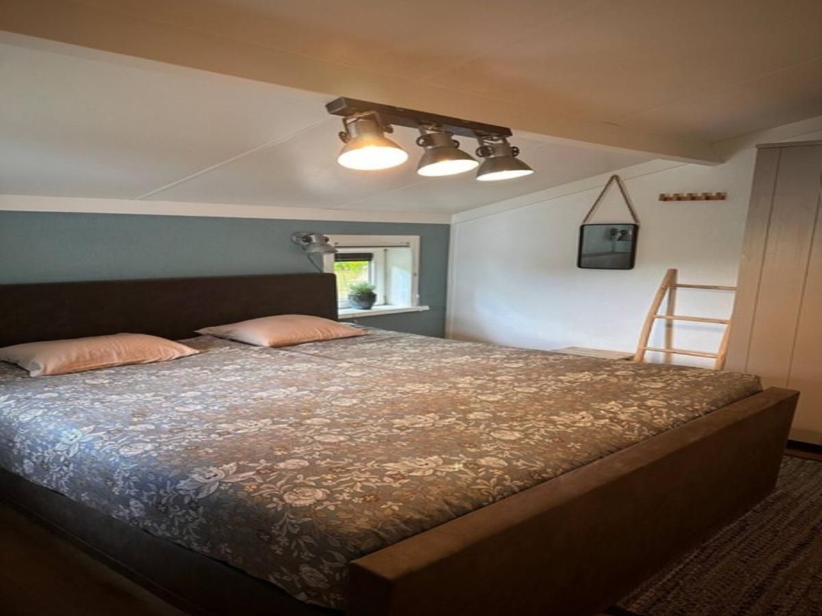 Gemuetliches Schlafzimmer in der Villa Belle Haan, einem Ferienhaus in De Haan, Westflandern, mit bequemem Doppelbett und stimmungsvoller Beleuchtung.