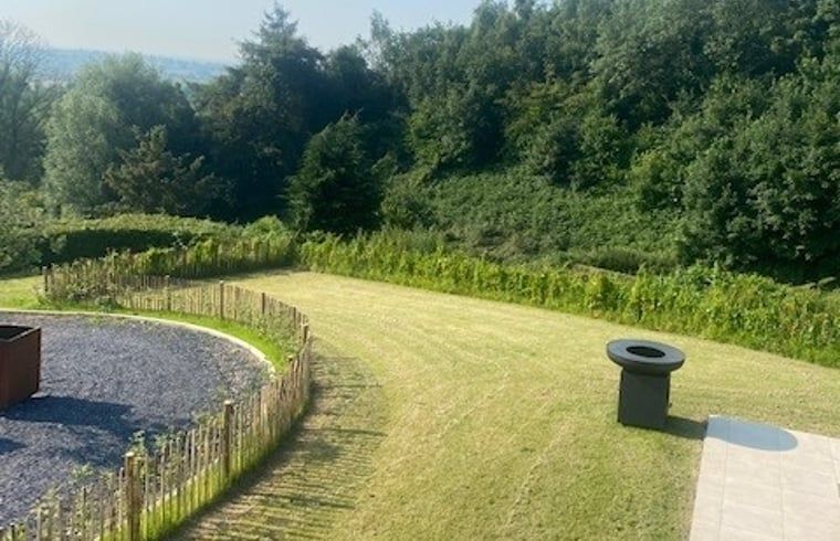 Ruhiger Garten und Landschaft im Ferienhaus in Heuvelland, Westouter, umgeben von gruener Natur in Westflandern, Belgien.