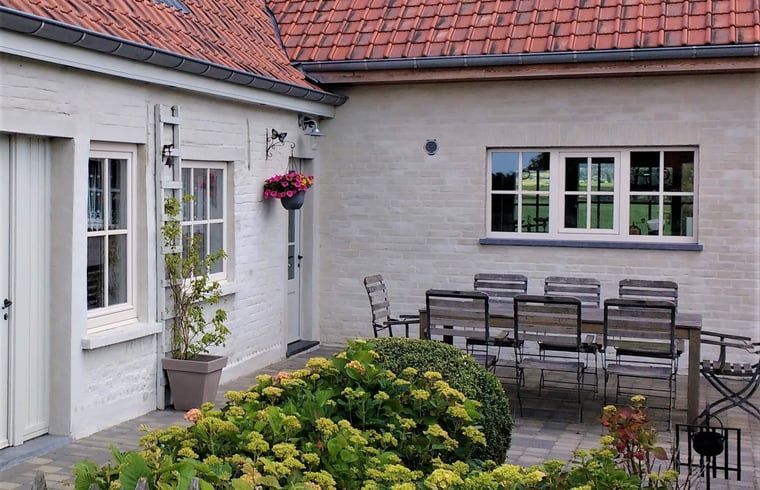 Geniessen Sie den schoenen Aussenbereich des Ferienhauses in Westouter, Heuvelland, Belgien, mit einer gemuetlichen Terrasse und einem gruenen Garten.