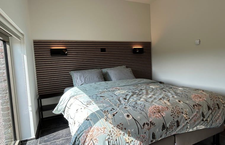 Luxurioeses Schlafzimmer im Ferienhaus in PROVEN, Proven, Westflandern, Belgien, mit eleganter Bettwaesche und moderner Wandbeleuchtung.