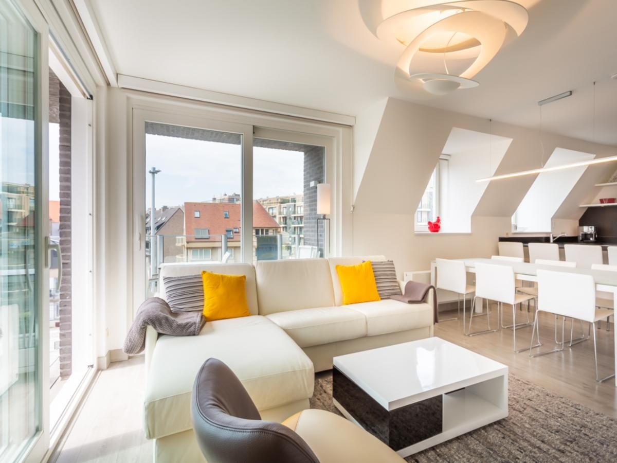 Lichte woonkamer van Aime 303 vakantiehuis in Koksijde, West-Vlaanderen, met moderne inrichting en uitzicht op de stad.