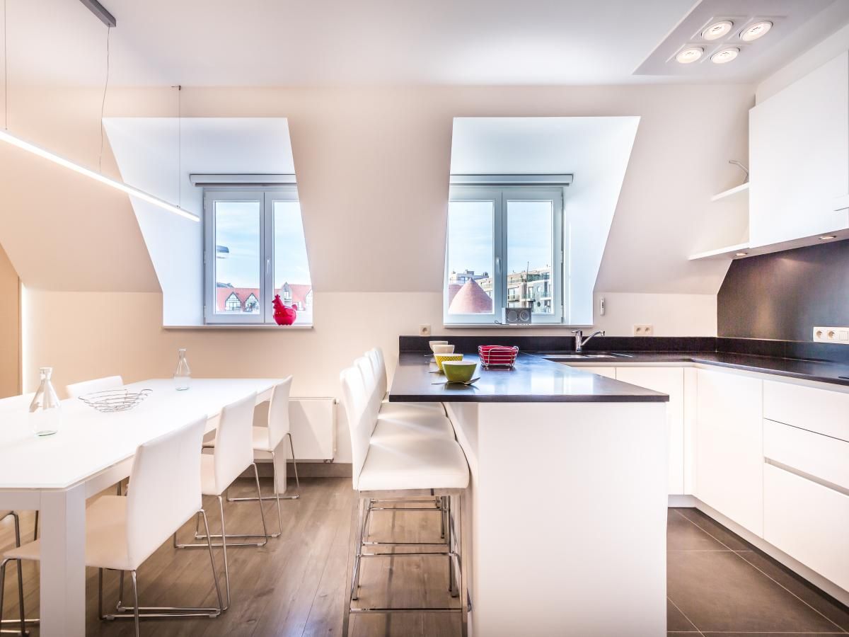 Stijlvolle keuken van Aime 303, een modern vakantiehuis in Koksijde, West-Vlaanderen, met lichtinval en uitzicht over de stad.