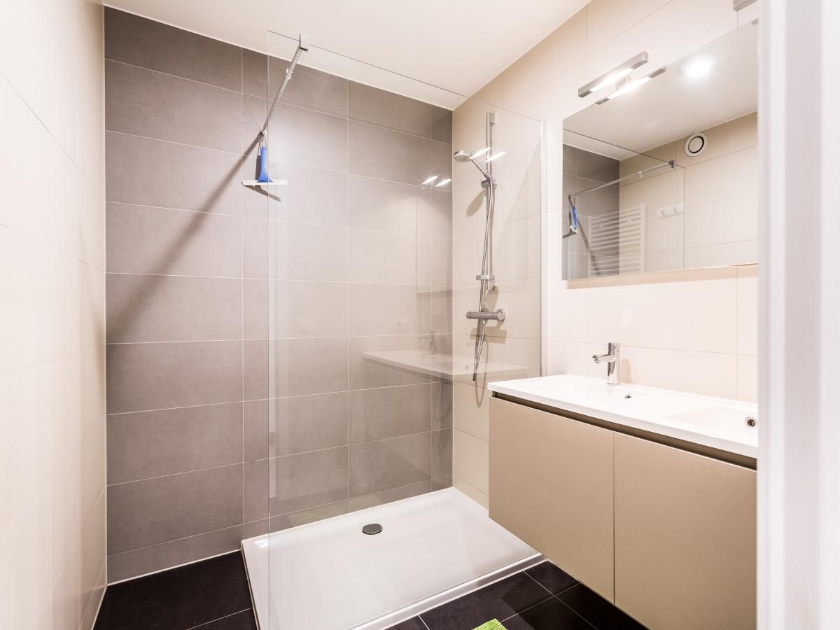 Moderne badkamer in vakantiehuis Aime 303 in Koksijde, West-Vlaanderen, met ruime douche en stijlvol wastafelmeubel.