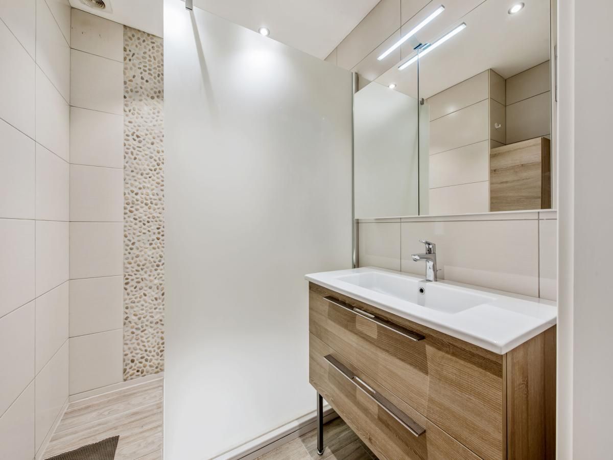 Moderne badkamer in Azcona Twee vakantiehuis, Koksijde, West-Vlaanderen met stijlvolle wastafel en ruime douche.