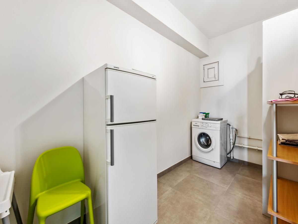 Praktische bijkeuken in Azcona Twee vakantiehuis, Koksijde, met koelkast en wasmachine, ideaal voor een comfortabel verblijf in West-Vlaanderen.
