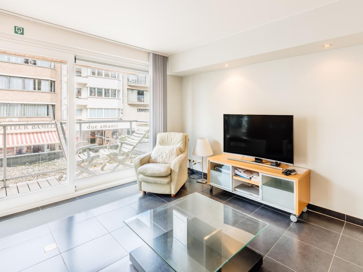 Modern living room in vacation home Brit First in Koksijde, West Flanders with spacious sitting area and city views.