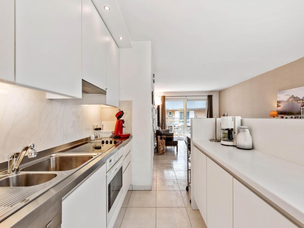Moderne keuken in Klokjesbloem Gelijkvloers vakantiehuis, Koksijde, West-Vlaanderen, met uitzicht op lichte woonruimte.