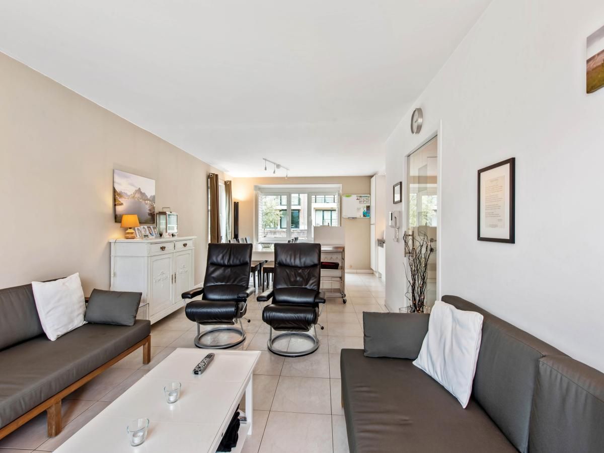 Gezellige woonkamer in Klokjesbloem Gelijkvloers vakantiehuis, Koksijde, West-Vlaanderen, met comfortabele zitruimte en veel lichtinval.