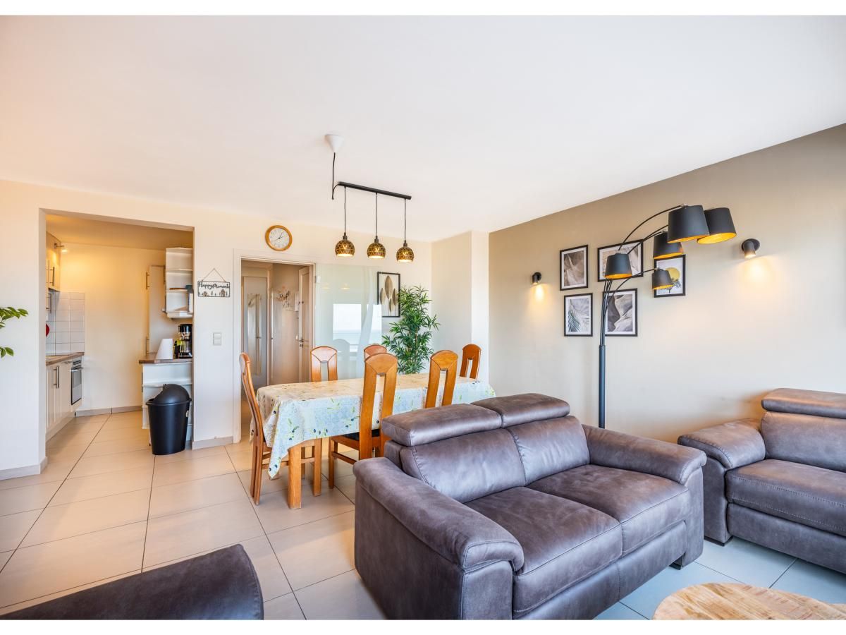 Gezellige woonkamer van vakantiehuis Cortina tweede in Koksijde, West-Vlaanderen, met comfortabele zithoek en eethoek.