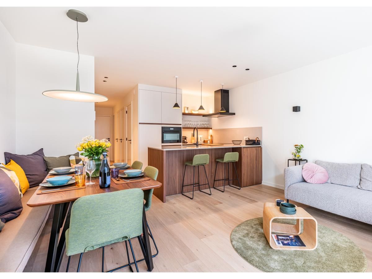 Stijlvolle woonkamer en keuken van La Balise Derde vakantiehuis in Koksijde, West-Vlaanderen, met moderne inrichting en gezellige zithoek.