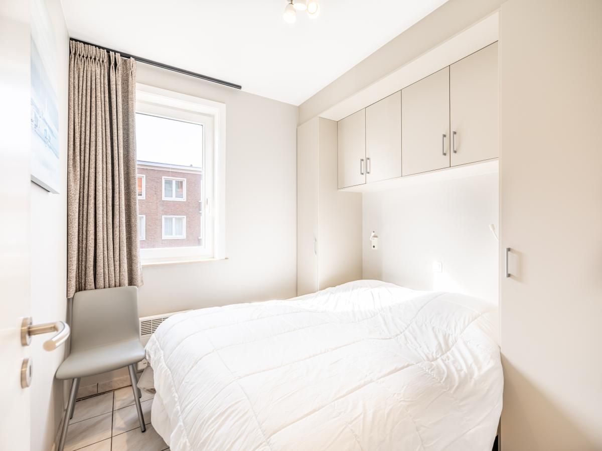 Sfeervolle slaapkamer in Delfien Eerste vakantiehuis, Koksijde, met licht interieur en uitzicht op de omgeving van West-Vlaanderen, Belgie.