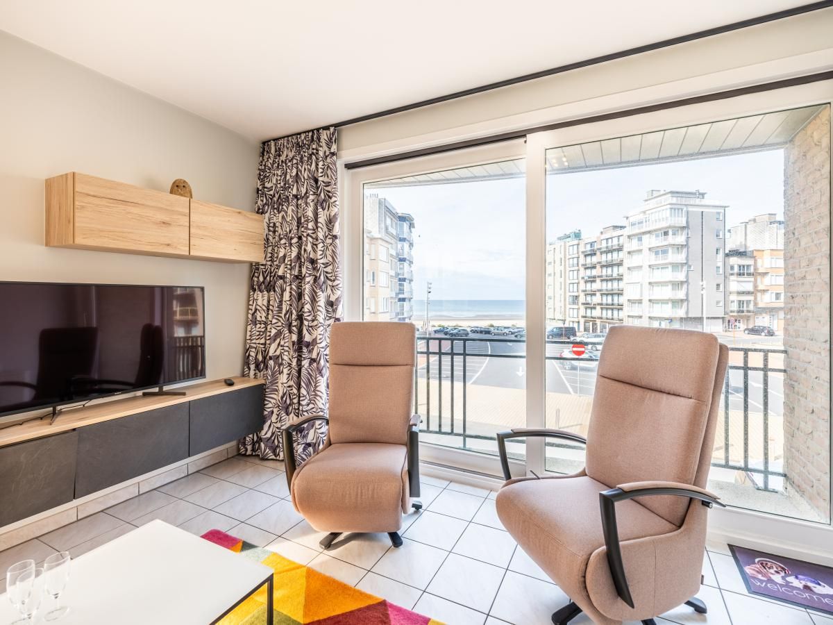 Lichte woonkamer van Delfien Eerste vakantiehuis in Koksijde, Belgie met uitzicht op zee en moderne inrichting.
