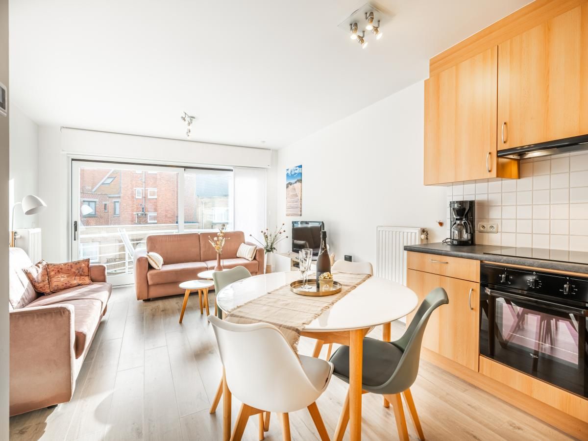 Lichte woonkamer van Gaston Lejeune tweede vakantiehuis in Koksijde, Belgie met moderne keuken en gezellig zitgedeelte.