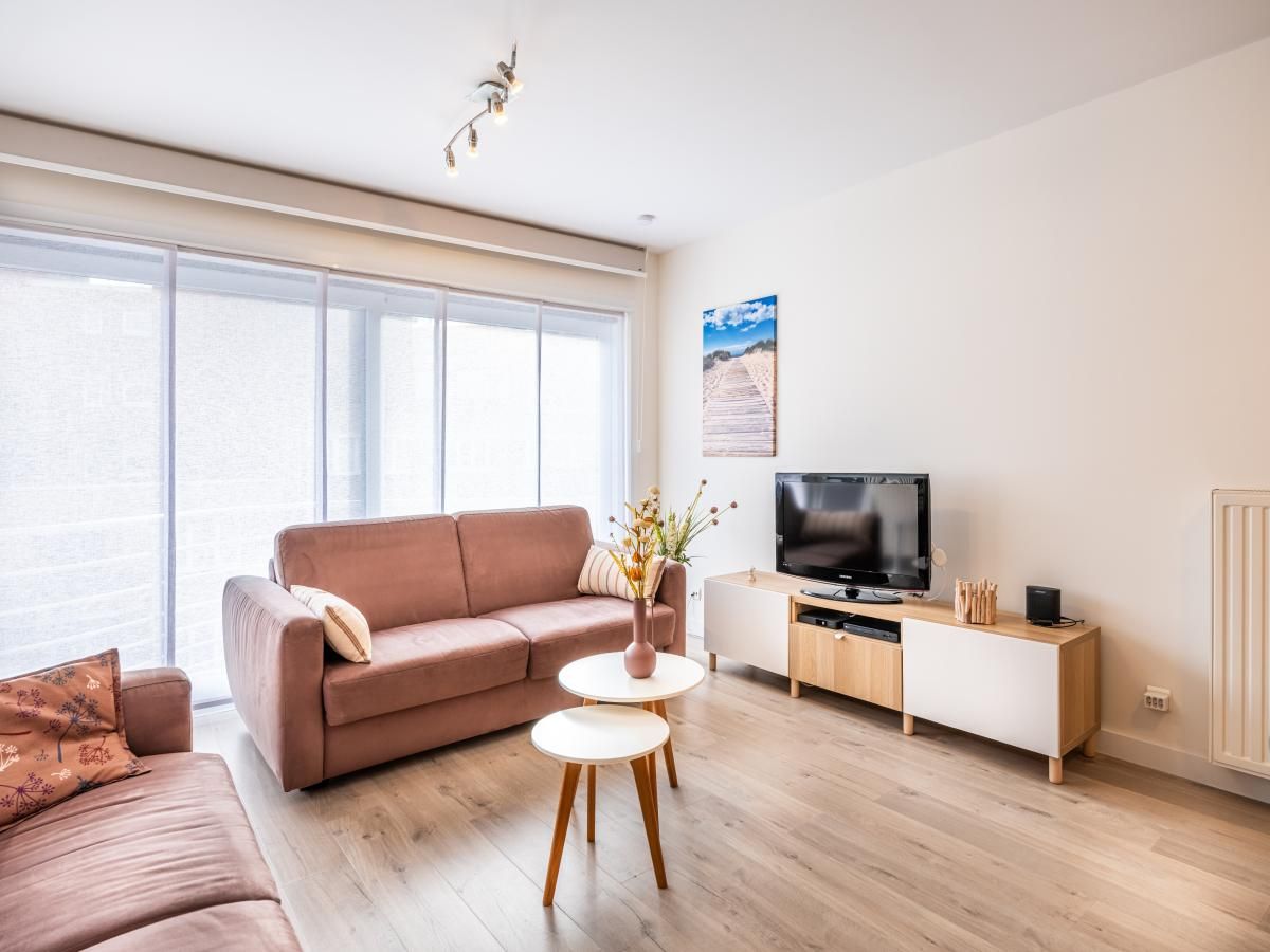 Gezellige woonkamer van Gaston Lejeune tweede vakantiehuis in Koksijde, West-Vlaanderen met comfortabele banken en moderne inrichting.