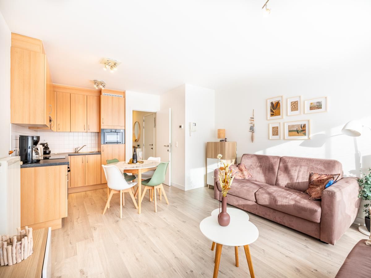 Gezellige woonkamer van Gaston Lejeune tweede vakantiehuis in Koksijde, West-Vlaanderen, met moderne keuken en comfortabele zithoek.