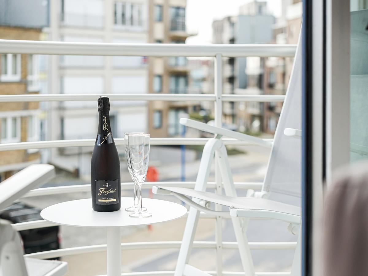Geniet van het balkon van Gaston Lejeune tweede, een vakantiehuis in Koksijde, West-Vlaanderen, met uitzicht op de levendige straat.