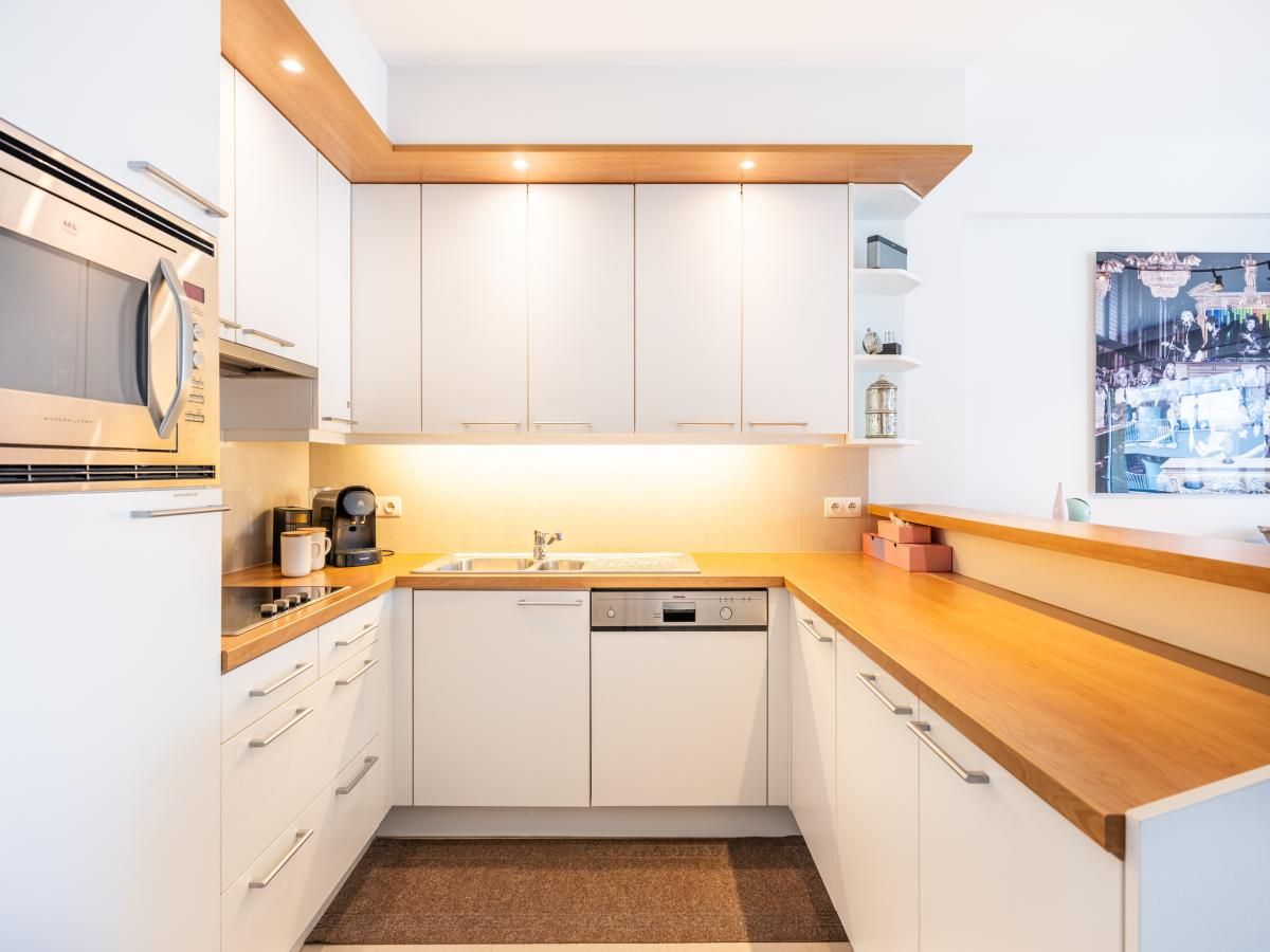 Moderne Kueche im Ferienhaus Guernsey second, Koksijde, Westflandern. Stilvolle Einrichtung mit Holzakzenten und modernen Geraeten.