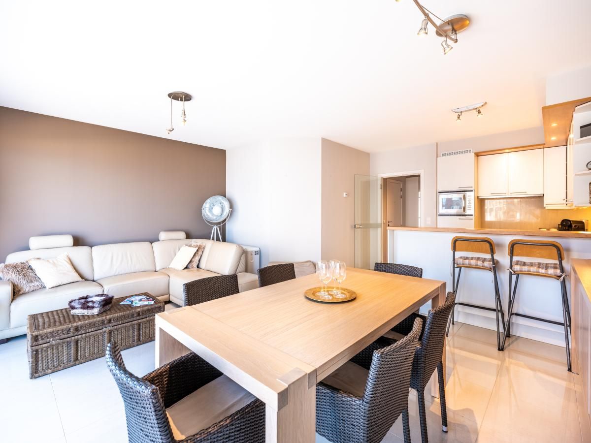 Stilvolles Wohnzimmer des zweiten Ferienhauses Guernsey in Koksijde, Westflandern, mit moderner Kueche und gemuetlicher Sitzecke.