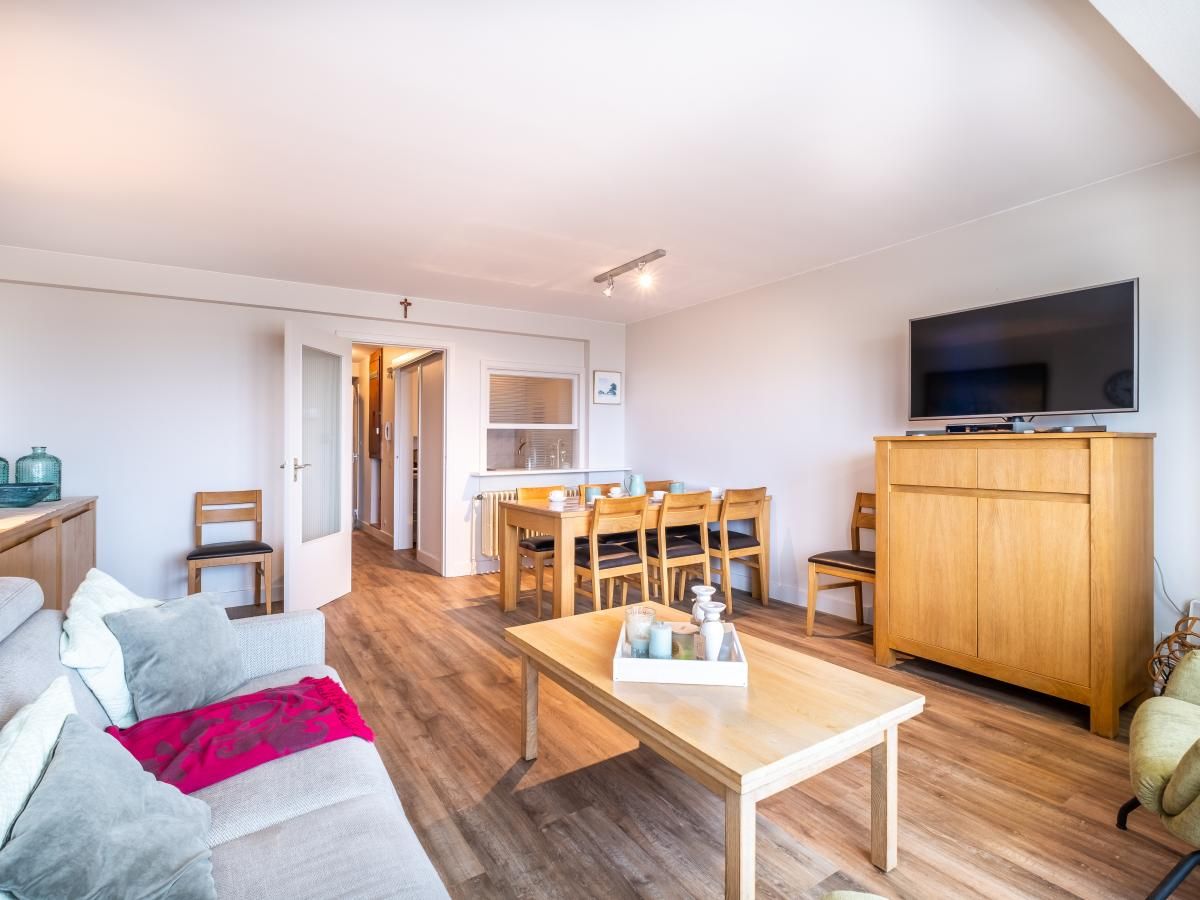 Gezellige woonkamer in Courant du Golfe vakantiehuis, Koksijde, met houten meubels en comfortabele zithoek, ideaal voor ontspanning.