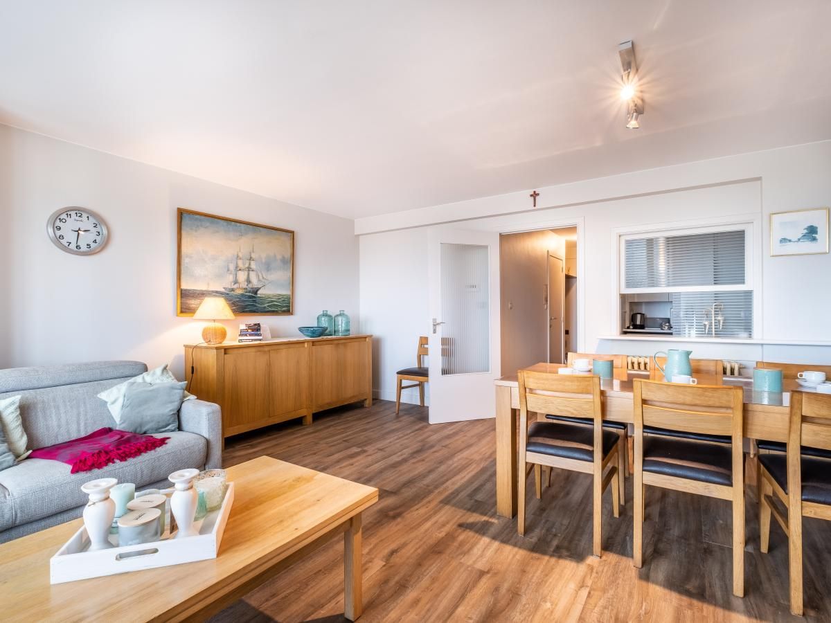 Gezellige woonkamer van Courant du Golfe vakantiehuis in Koksijde, West-Vlaanderen. Comfortabele zitruimte en eethoek voor een ontspannen verblijf.