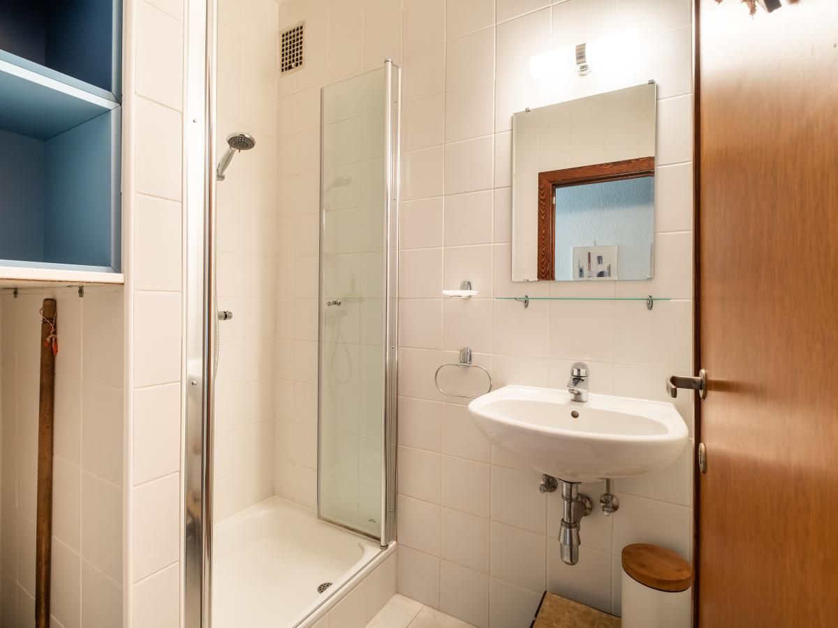 Moderne badkamer in Juvamy gelijkvloers vakantiehuis, Koksijde, West-Vlaanderen, met strakke douche en wastafel.