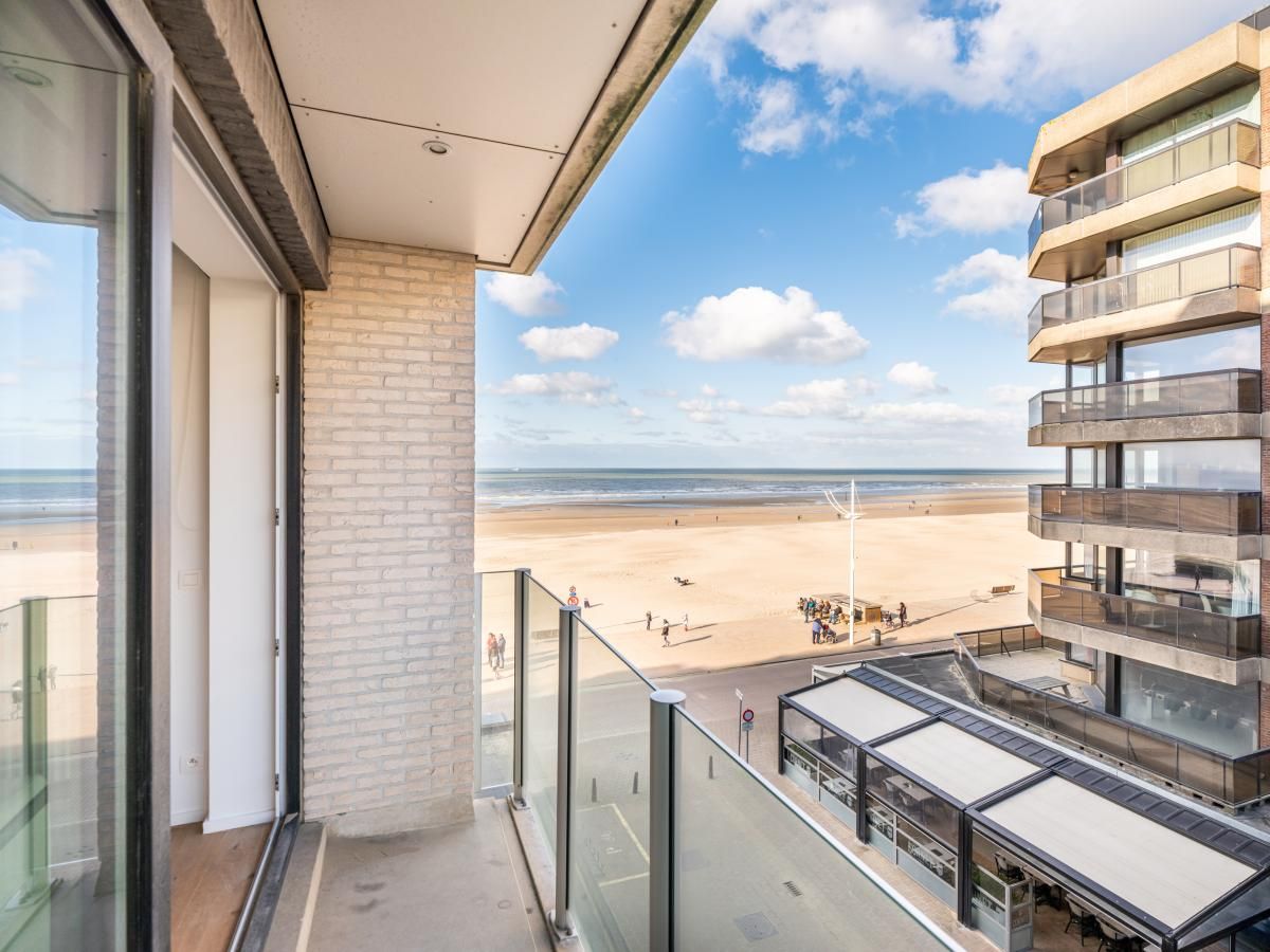 Lichte woonkamer van vakantiehuis De Dijk derde in Koksijde, West-Vlaanderen, met panoramisch uitzicht op het strand en de zee.