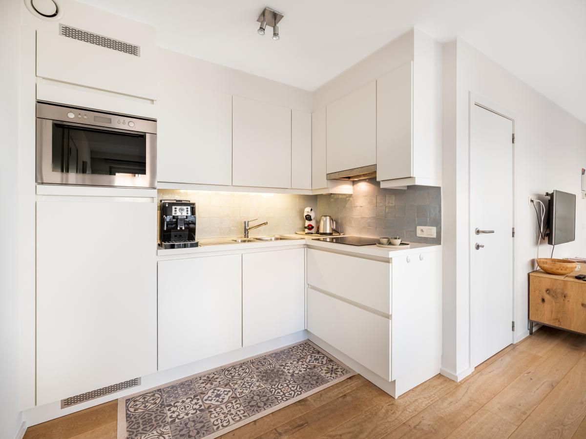 Lichte woonkamer van De Dijk derde vakantiehuis in Koksijde, West-Vlaanderen, met moderne inrichting en grote ramen voor een ruimtelijk gevoel.
