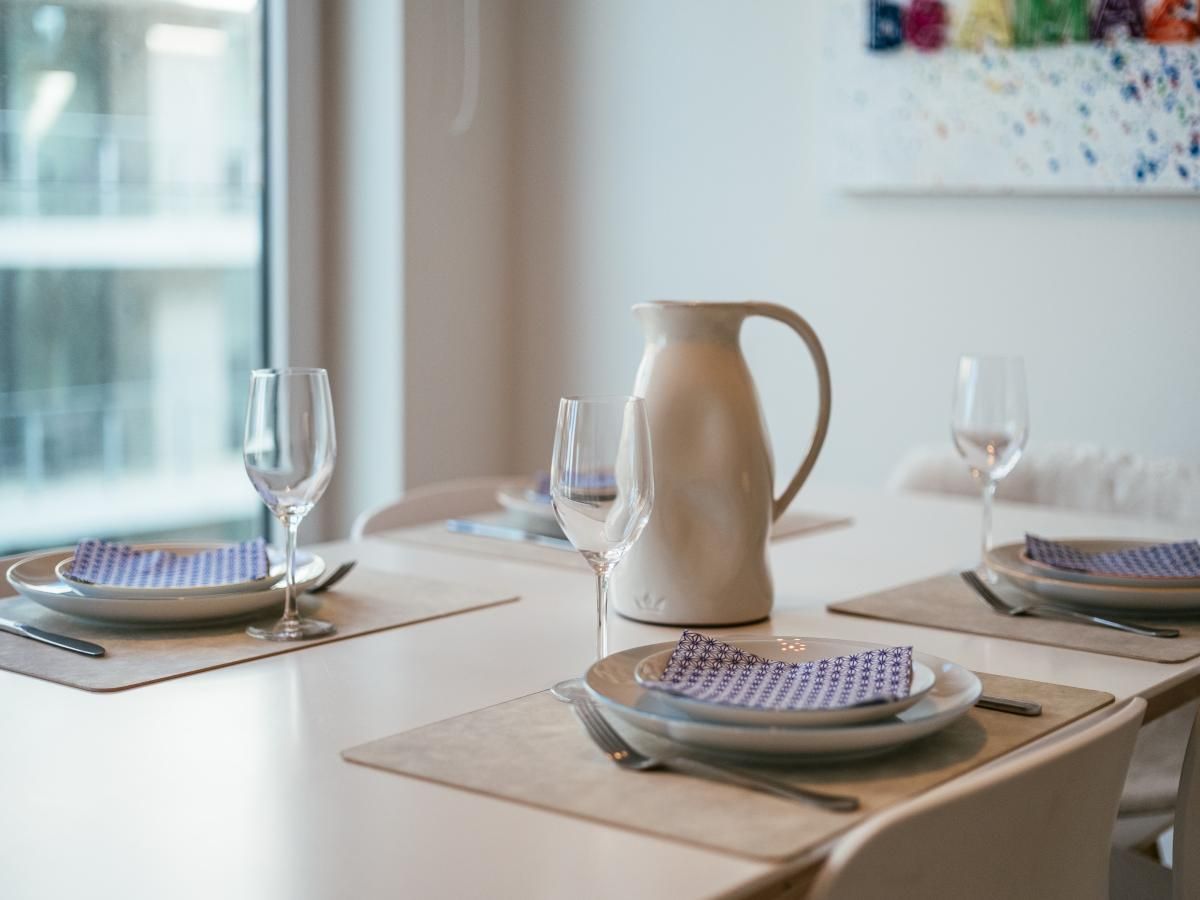 Lichte eetkamer in De Dijk derde vakantiehuis in Koksijde, West-Vlaanderen, met modern interieur en uitzicht op de stad.