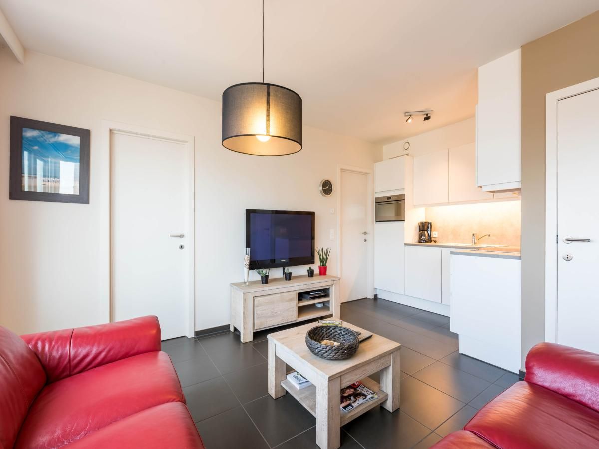 Moderne woonkamer in vakantiehuis De Dijk zesde in Koksijde, West-Vlaanderen, met comfortabele inrichting en open keuken.