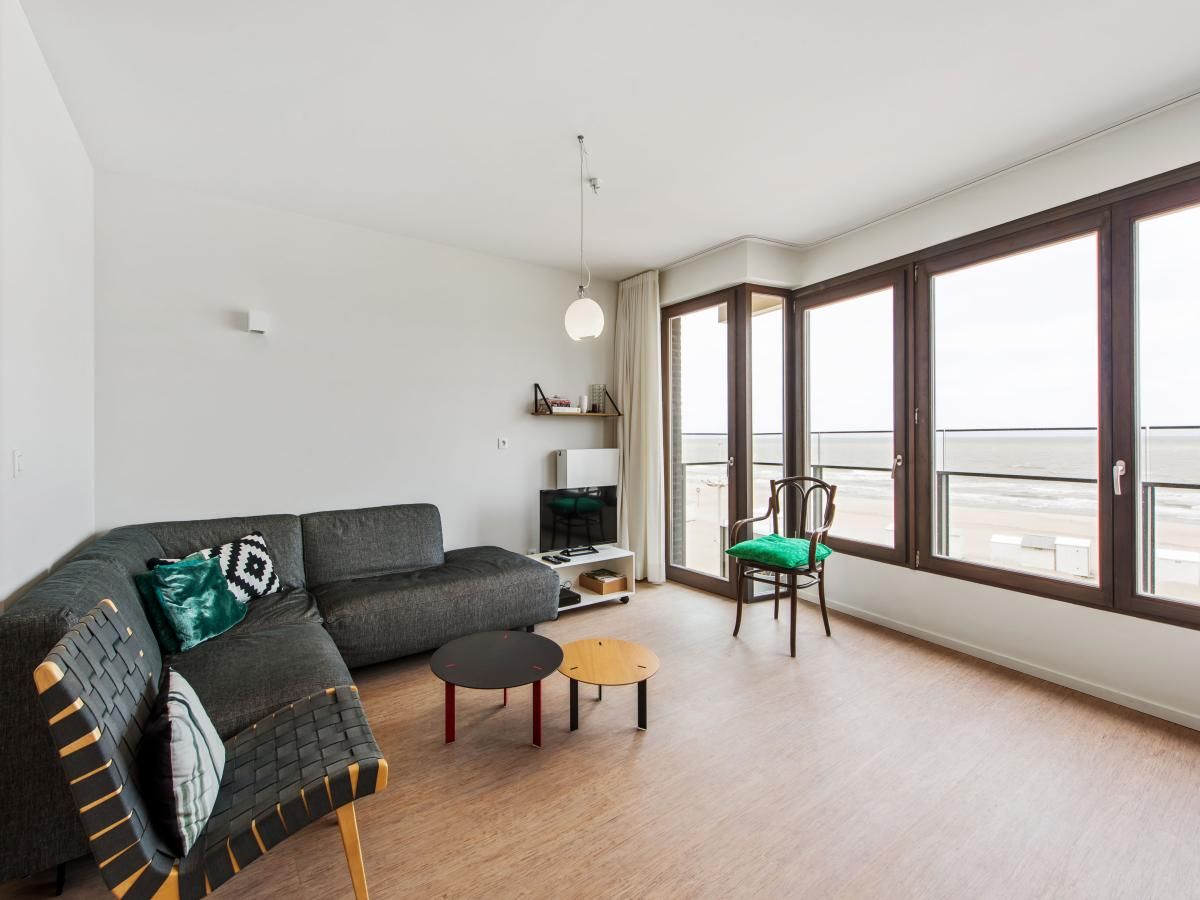 Lichte woonkamer in De Meeuwen derde vakantiehuis met zeezicht in Koksijde, West-Vlaanderen, Belgie.