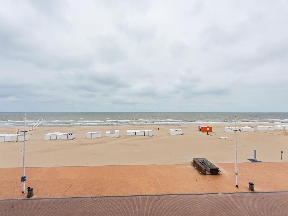 Uitzicht op het strand vanuit De Meeuwen derde vakantiehuis in Koksijde, West-Vlaanderen, met zeezicht en zandduinen.