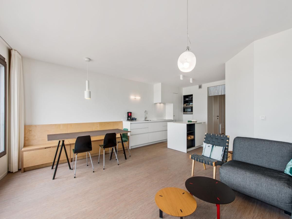 Moderne binnenruimte van De Meeuwen derde vakantiehuis in Koksijde, West-Vlaanderen, met stijlvolle keuken en eetgedeelte.