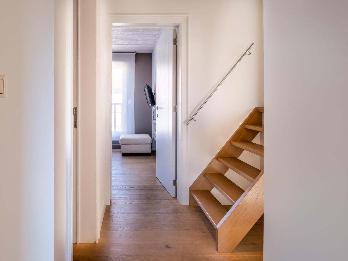 Binnenruimte van vakantiehuis Tranquil in Koksijde, West-Vlaanderen, met houten trap en moderne inrichting voor een ontspannen verblijf.