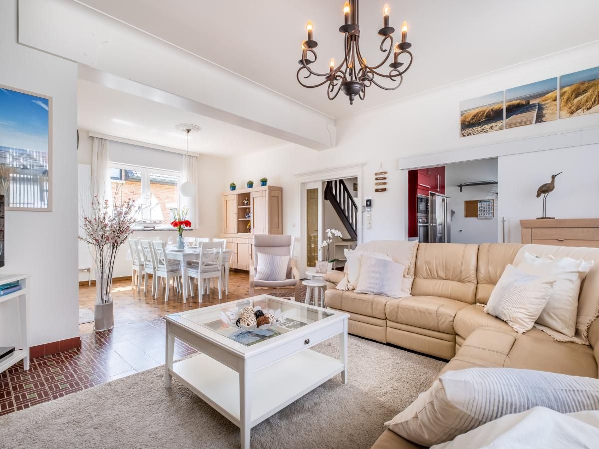 Gezellige woonkamer van vakantiehuis Porpoises in Koksijde, West-Vlaanderen, met comfortabele zithoek en stijlvolle eethoek.