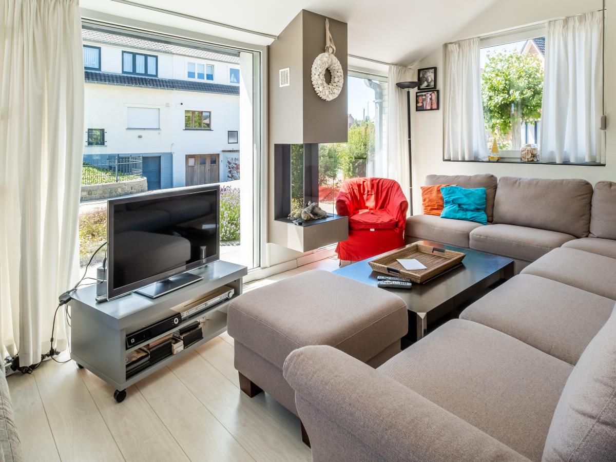 Lichte woonkamer van vakantiehuis Guillaume in Koksijde, West-Vlaanderen met comfortabele zithoek en moderne inrichting.