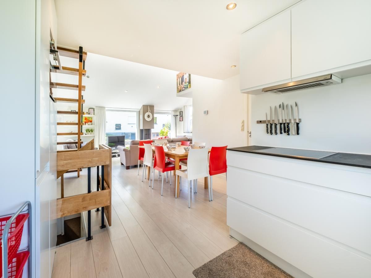 Moderne keuken en eetruimte in vakantiehuis Guillaume, Koksijde, West-Vlaanderen, Belgie. Gezellige sfeer met veel natuurlijk licht.