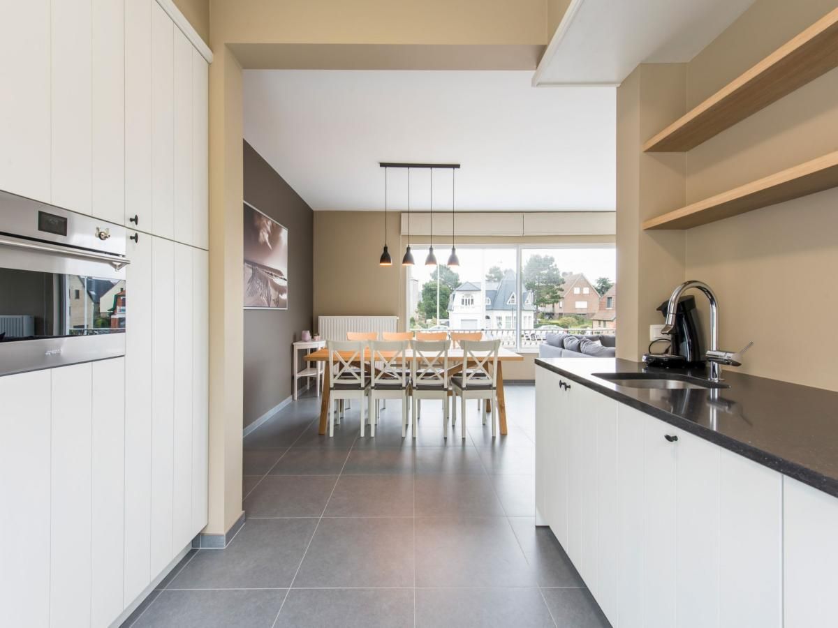 Stylish kitchen and dining area in La Vachequirit vacation home, Koksijde, West Flanders, overlooking a quiet residential area.