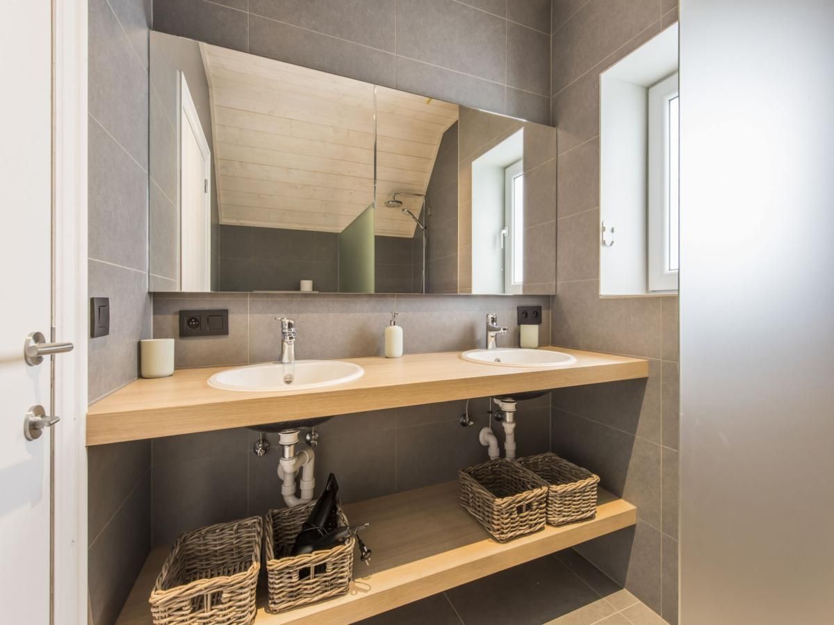 Stylish bathroom in vacation home La Vachequirit, Koksijde, with modern sink and spacious mirrors for a comfortable stay in West Flanders.