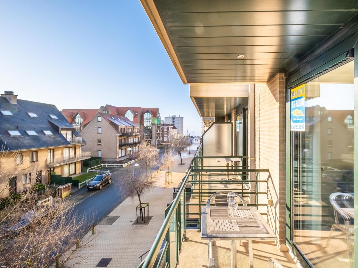 Geniet van het zonovergoten balkon van vakantiehuis Pablito trois in Koksijde, West-Vlaanderen, met uitzicht op de rustige straat.