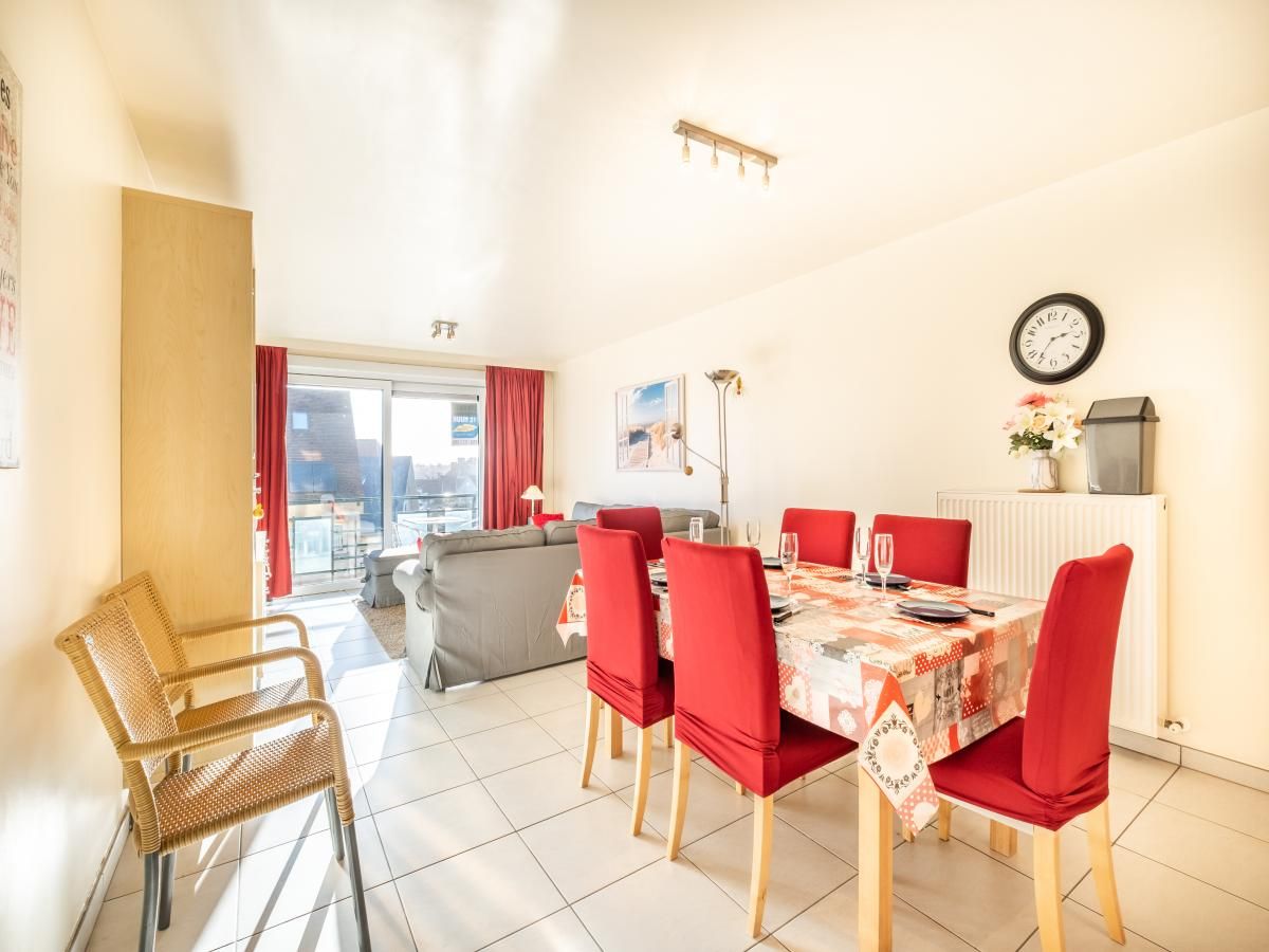 Gezellige eetkamer in vakantiehuis Pablito trois in Koksijde, West-Vlaanderen, met uitzicht op balkon en moderne inrichting.