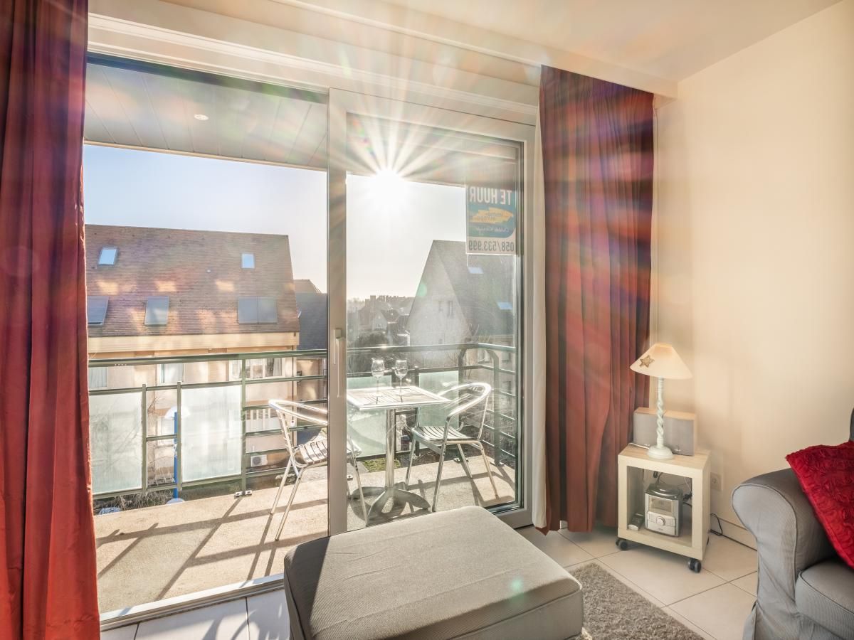 Zonnig balkon van vakantiehuis Pablito trois in Koksijde, West-Vlaanderen met uitzicht op rustige omgeving.