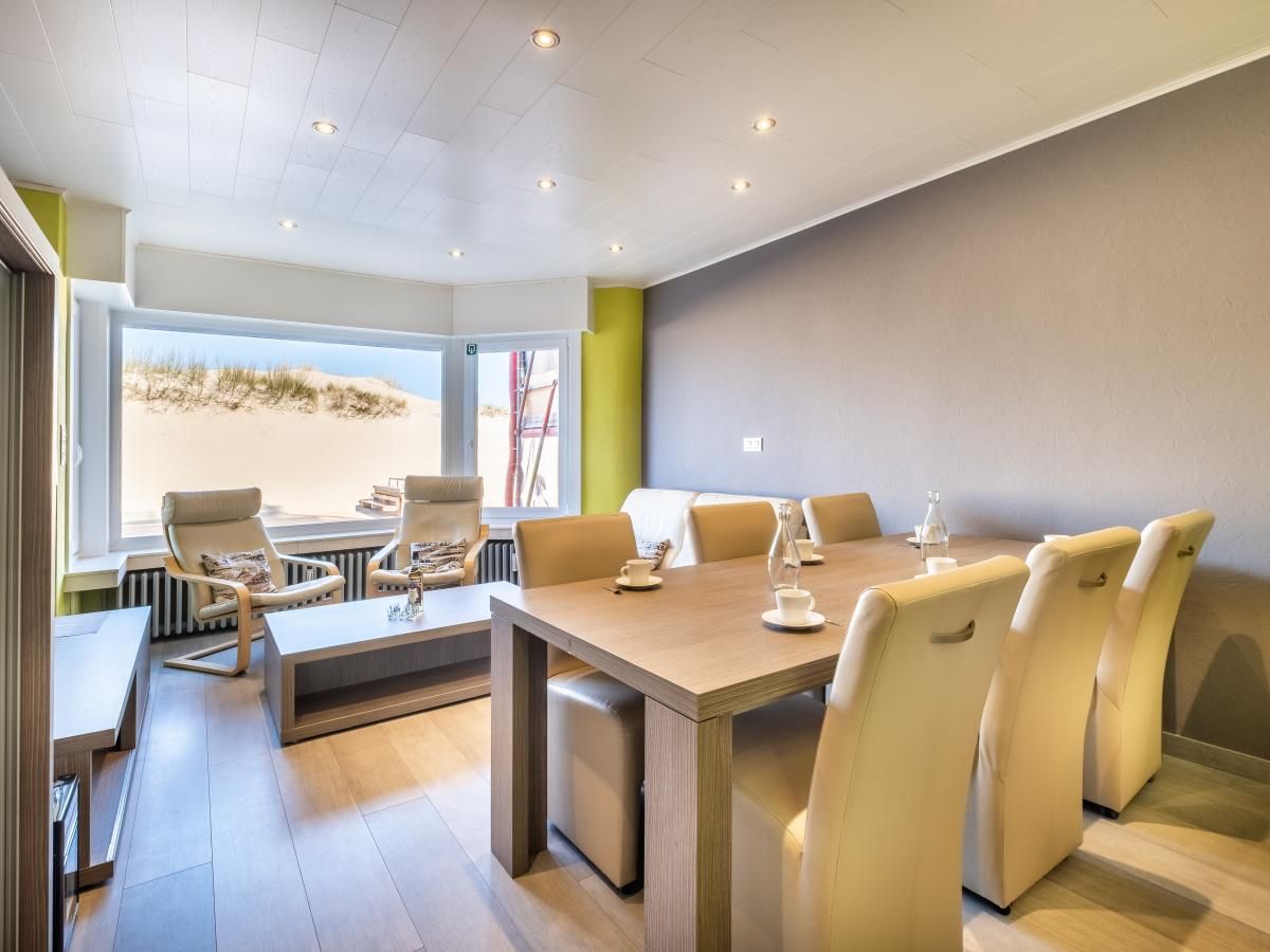 Stijlvol ingerichte woonkamer van vakantiehuis Zeezicht GV in Koksijde, West-Vlaanderen met uitzicht op de duinen.