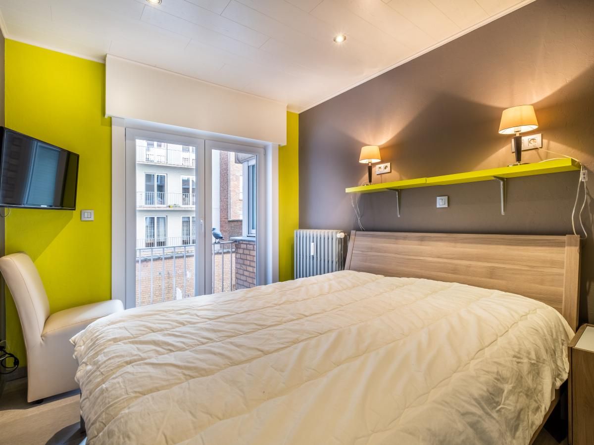 Gezellige slaapkamer in vakantiehuis Zeezicht GV, Koksijde, met moderne inrichting en uitzicht op de omgeving van West-Vlaanderen.