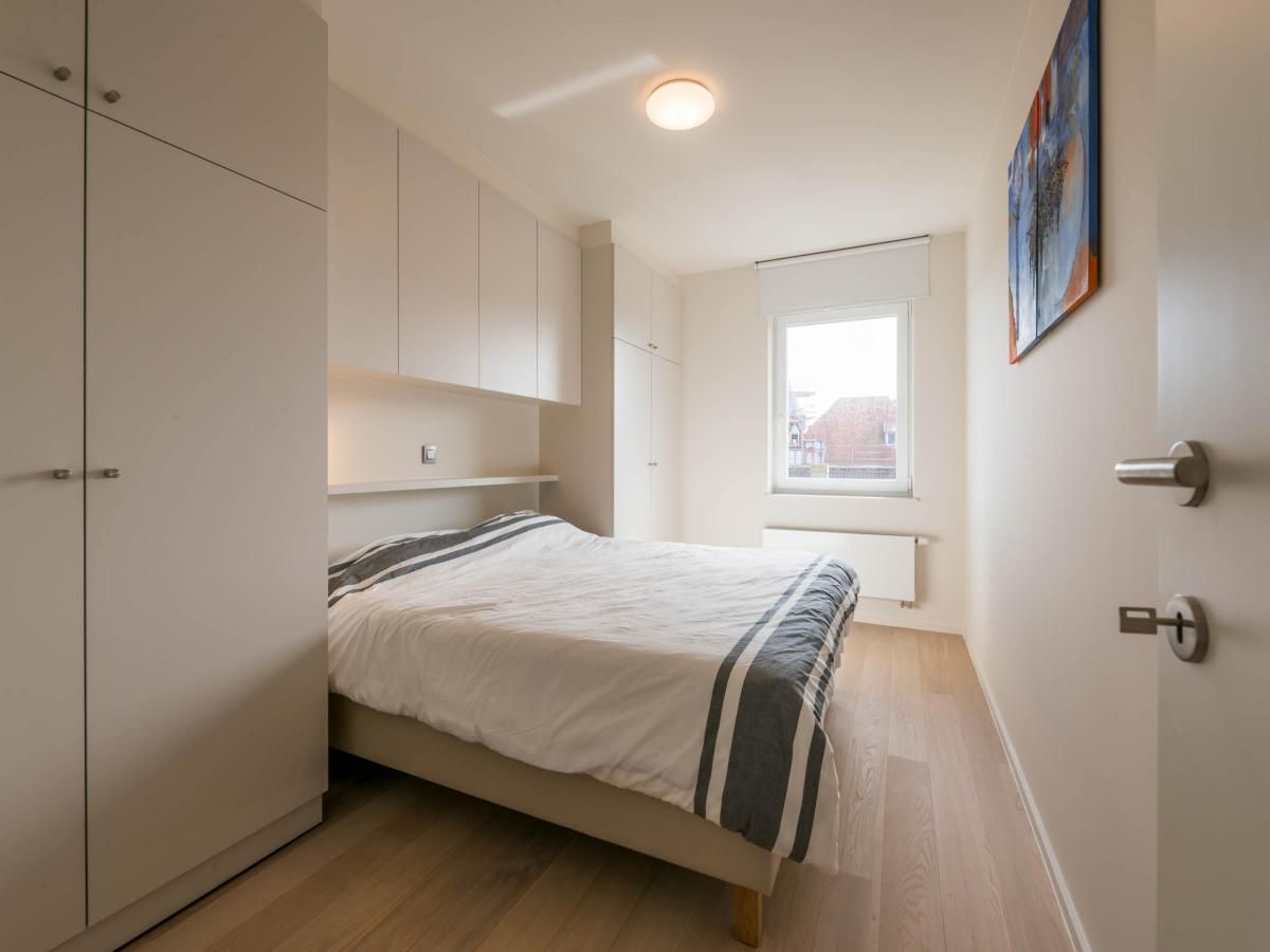 Sfeervolle slaapkamer in Bon Accueil tweede vakantiehuis, Koksijde, West-Vlaanderen, met moderne inrichting en natuurlijk licht.
