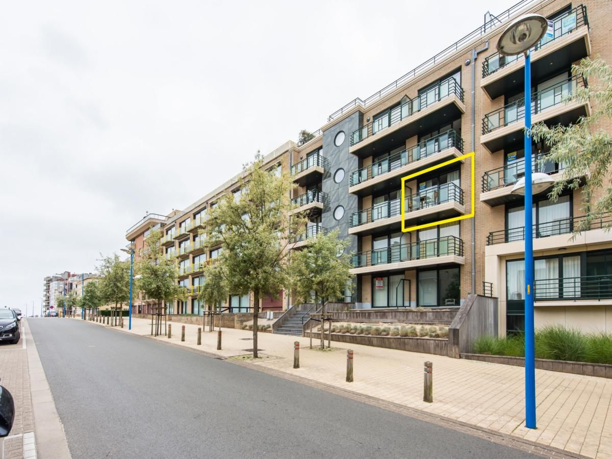 Paco derde vakantiehuis in Koksijde, West-Vlaanderen, biedt een modern balkon met uitzicht op een rustige straat en groene omgeving.