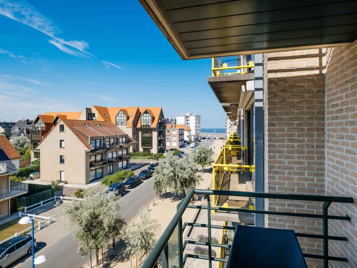 Uitzicht vanaf het balkon van vakantiehuis Paco vierde in Koksijde, West-Vlaanderen, met zicht op de kust en omliggende architectuur.